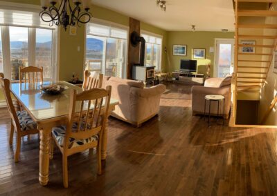Chalet Berceau de l'Anse - Salon et salle à manger baignés de lumière avec vue fleuve